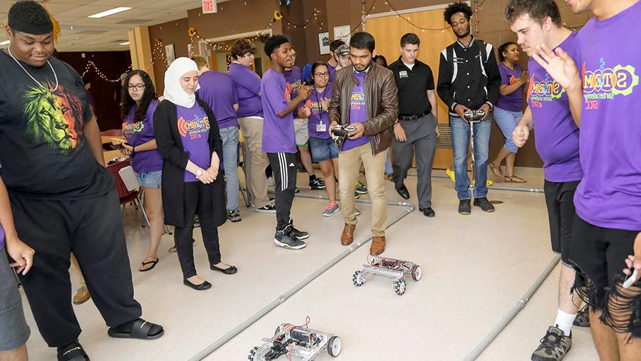 coding and robotics contestants racing remote controlled robots